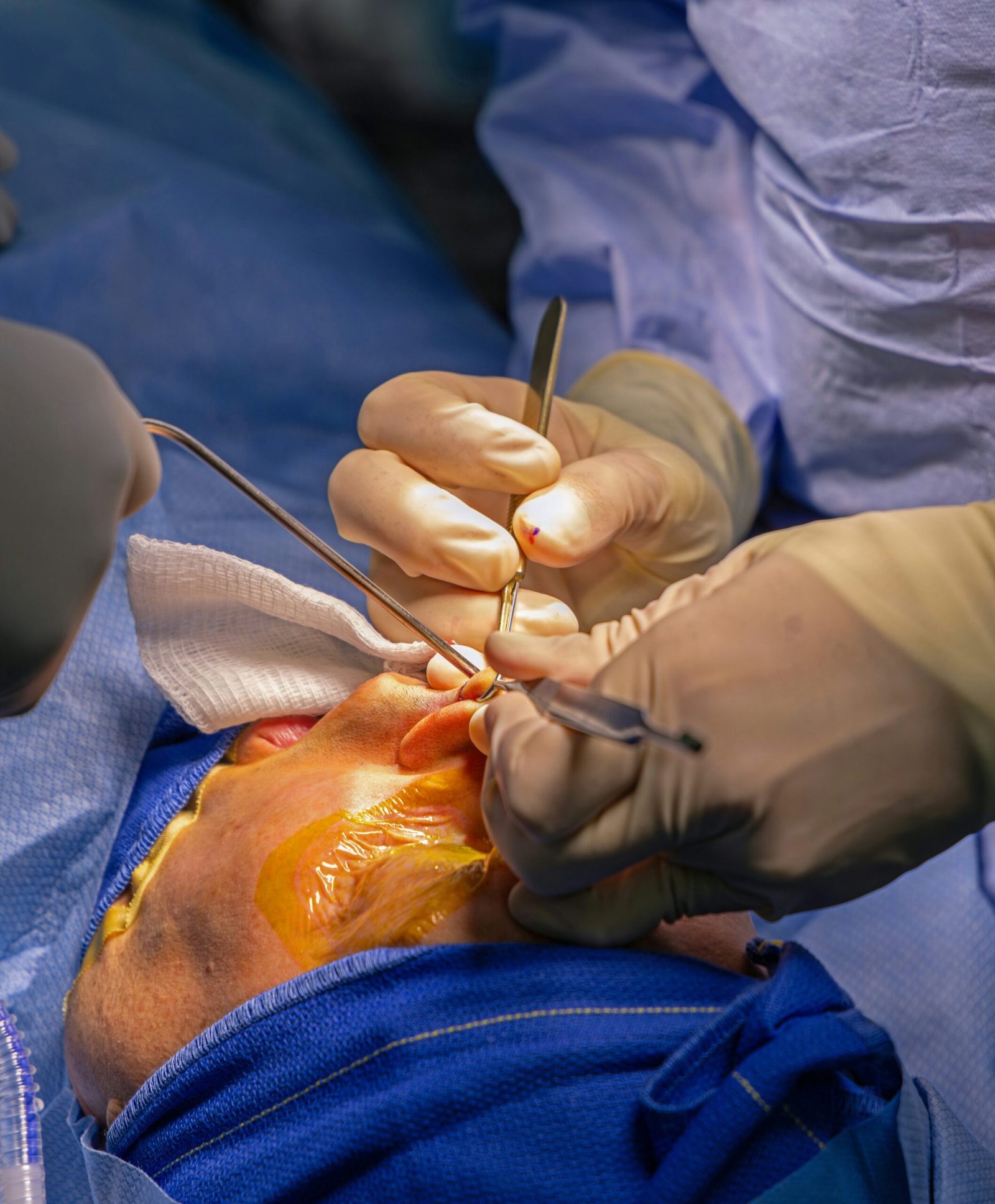 Surgeons using surgical instruments under operating lights